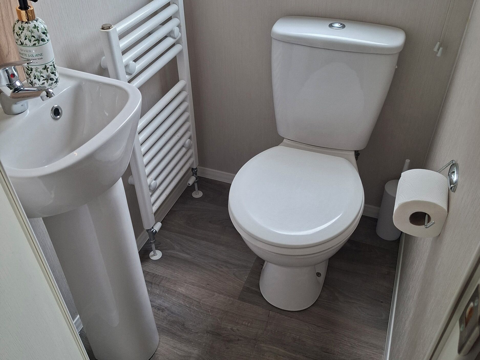 A bathroom with a toilet, a sink, and a radiator.