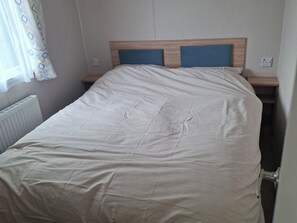 A single bed with a wooden headboard and two bedside tables.