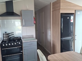 Una cocina compacta con estufa, horno y refrigerador.
