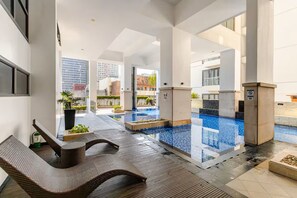 Ein moderner Innenpoolbereich mit Sitzgelegenheiten und Blick auf die Stadt.