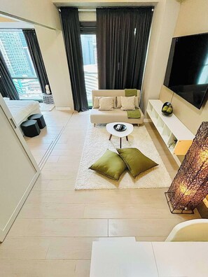 Ein modernes Wohnzimmer mit einer Couch, einem Couchtisch und einem Fernseher.