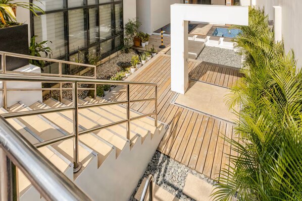 A modern outdoor area with a wooden deck, a pool, and potted plants. - BNEW! Cozy 1-BR Studio in High End Makati with Pool, Gym, Jacuzzi, Sauna (Makati)