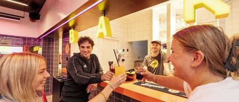 A bar area with a counter and illuminated letters spelling 'BAR' on the wall.