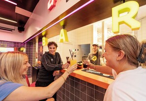 A bar area with a counter and illuminated letters spelling 'BAR' on the wall.