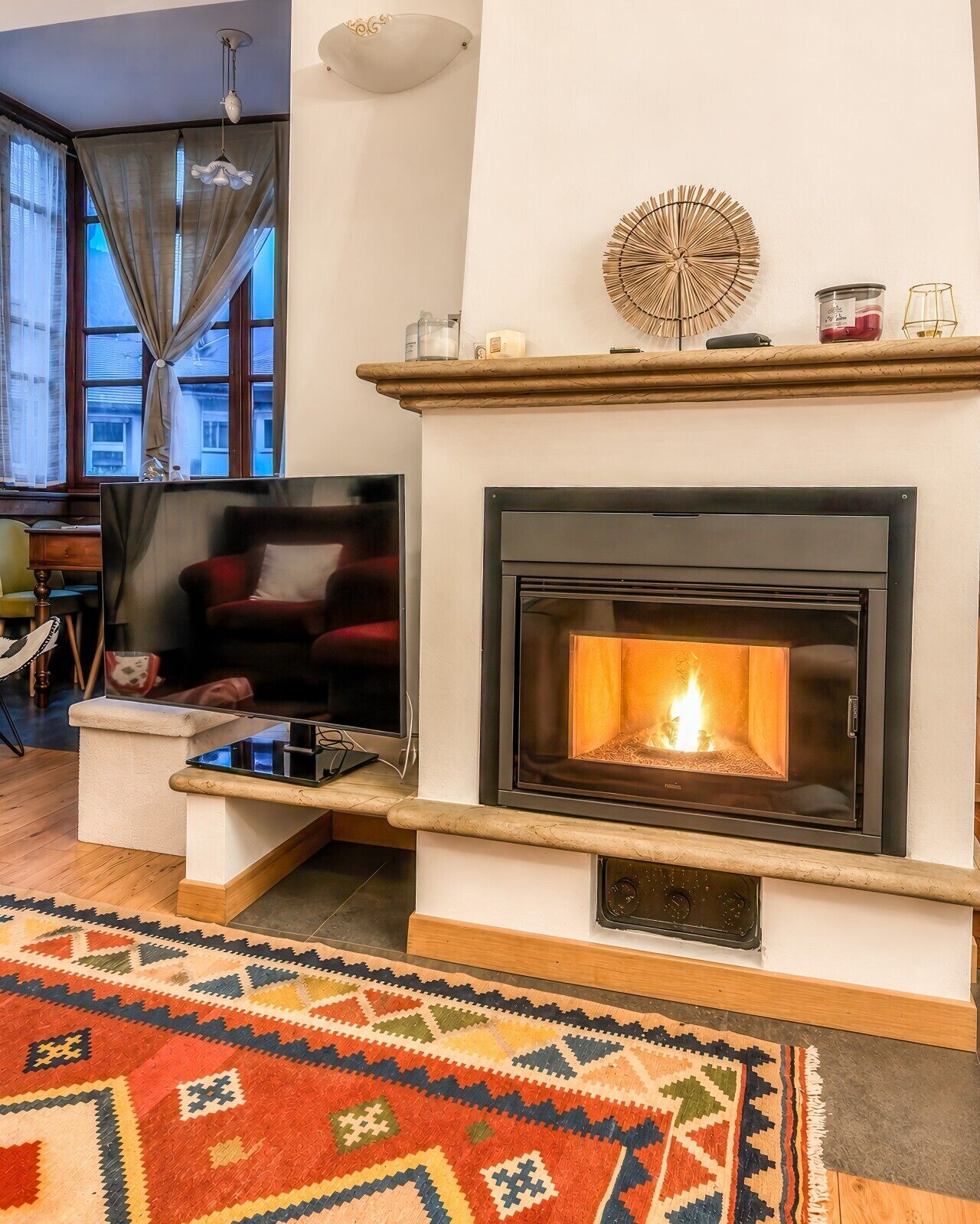 Een woonkamer met een open haard, een televisie en een kamerbreed tapijt.