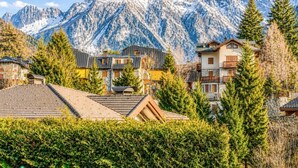 A mountain village with snow-capped peaks, residential buildings, and dense greenery. - Le Ville Apartment - Ponte di Legno (Ponte di Legno)