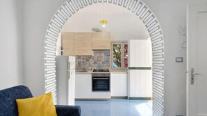 Una cocina moderna con armarios blancos, un salpicadero estampado y un horno empotrado.