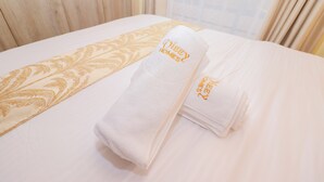 A neatly made bed with a folded towel and a decorative pillow. - Studio in Nairobi South B (Nairobi)