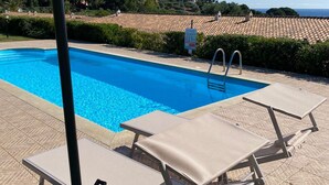 A swimming pool with lounge chairs, a pergola, and a view of mountains. - Mandy and Dolly's house with sea view and pool (tertenia)