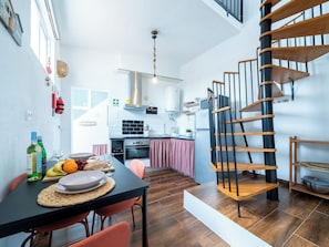 Une cuisine moderne avec un coin repas, un escalier et une vue sur la ville.