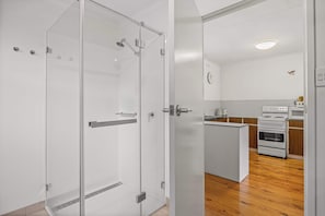 Una cocina moderna con armarios blancos, una isla central y un horno empotrado.