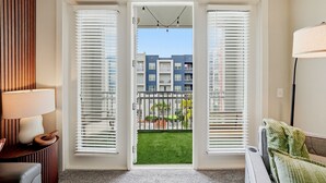 A room with a view of a balcony, a lamp, and a sofa. - Bright 2BR/2BA Tampa Haven: Productivity & Relaxation (Tampa)