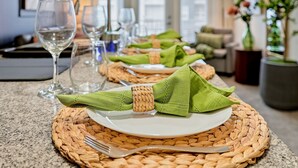 A dining table set with green napkins, a woven placemat, and a fork. - Bright 2BR/2BA Tampa Haven: Productivity & Relaxation (Tampa)