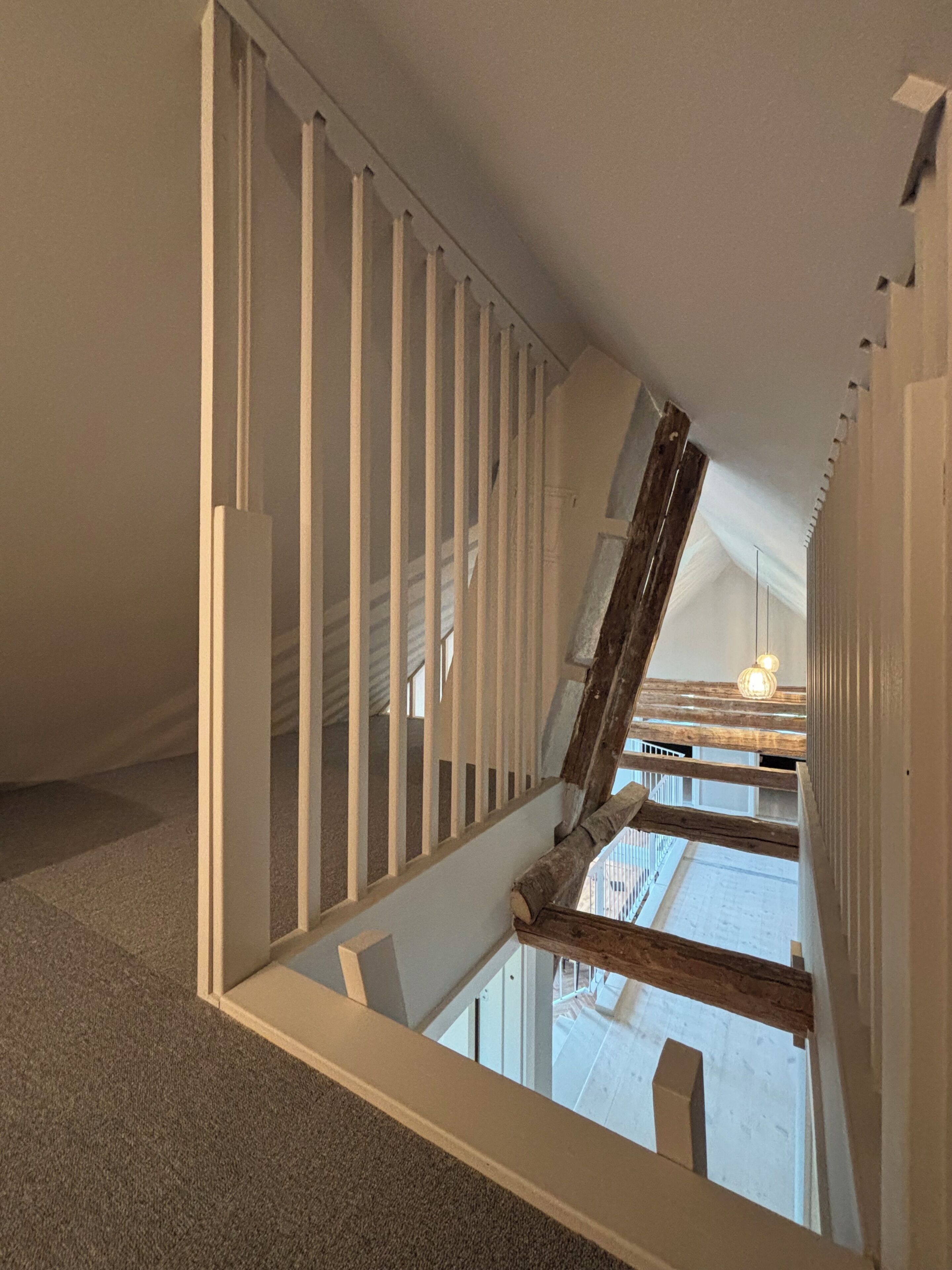 A staircase with white railings leading to an upper floor.