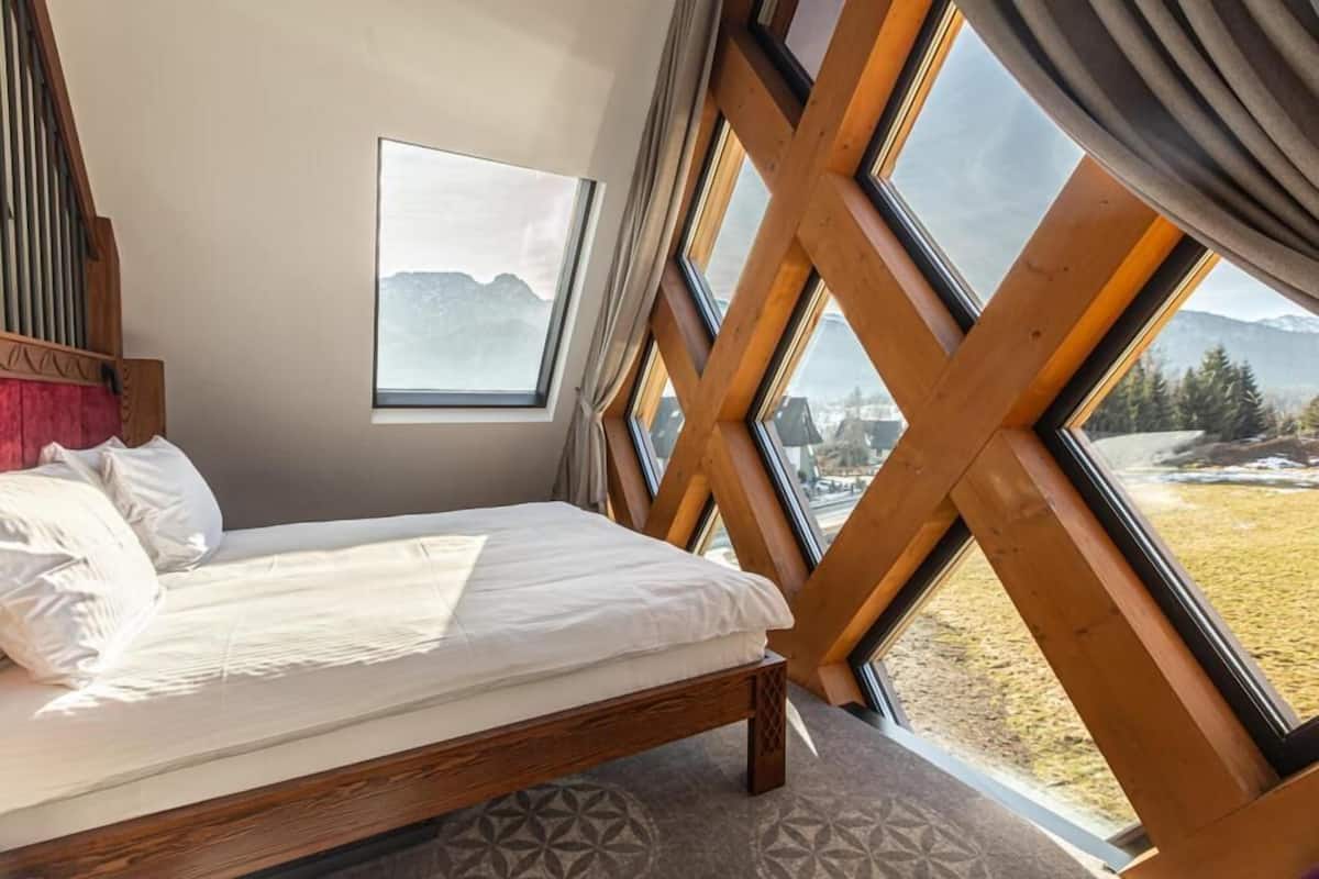 Une chambre à coucher avec un lit, une fenêtre et une vue sur les montagnes.