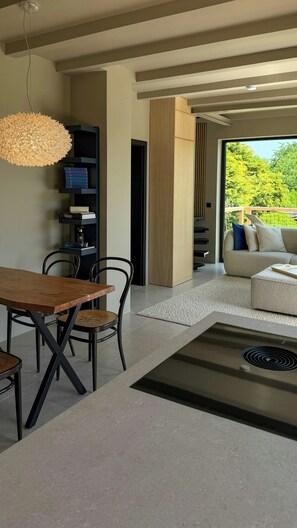 Un espacio moderno para vivir con comedor, sofá y vistas a zonas verdes.
