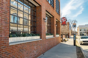 A brick building with large windows, a 'Second Best' sign, and a parking sign indicating a zone. - "Second Best" Condo with King Bed in the Heart of Brush Park (Detroit)