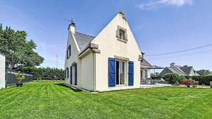 Ein Haus mit geneigtem Dach, Schornstein und einem kleinen Fenster.