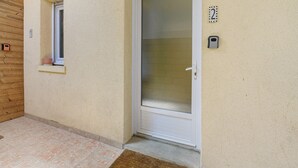 A door with a glass panel, a small window, and a mailbox on the wall. - Gîte Jersey – Your Vacation Close to the Sea (Bréhal)