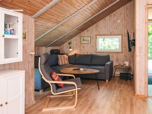 A cozy loft-style room with a wooden ceiling, a gray sofa, a wooden coffee table, and a small side table. - 4 Star Holiday Home in Hovborg (Hovborg)