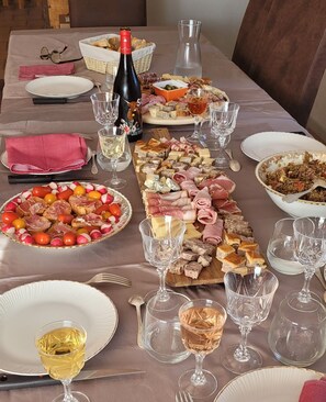 A table set for a meal with various food items, wine glasses, and a bottle of wine.