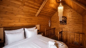 Une pièce en bois avec un lit, un lustre et une statue de Bouddha.