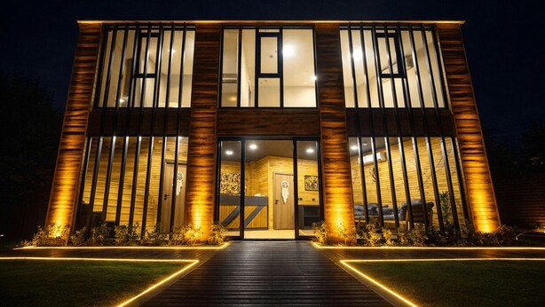 Un edificio moderno con fachada de madera, ventanas amplias y una entrada central.