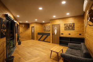 A wooden interior with a staircase, a couch, and artwork on the walls. - City Bungalow Hotel (Edirne)