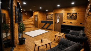 Un interior moderno con suelo de madera, una escalera, un conjunto de sofás, una mesa de centro y una chimenea.