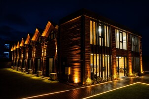 A modern building with a series of connected rooms, large windows, and a well-lit exterior.