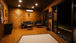 Una habitación acogedora con paredes de madera, un sofá, una mesita de centro y una planta en maceta.