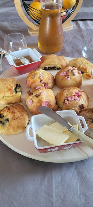 Een ontbijt kar met muffins, een botervak en een waterkan met thee.