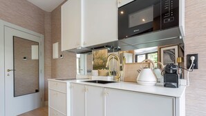A modern kitchen with white cabinetry, a black microwave, and a coffee machine. - Exclusive Studio in Salamanca Isla de la Rua I (Salamanca)