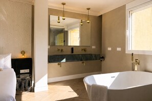 A modern bathroom with a large mirror, a bathtub, and a vanity with a marble countertop. - Refined Apartment in Seville s Historic Centre General Casta os (Seville)