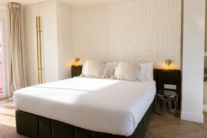 A large bed with a dark headboard, two bedside lamps, and a patterned wall. - Refined Apartment in Seville s Historic Centre General Casta os (Seville)