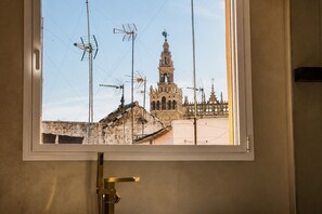 A window with a view of a historic building with a bell tower, surrounded by antennas. - Refined Apartment in Seville s Historic Centre General Casta os (Seville)