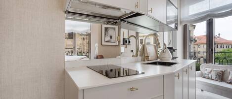 Una cocina moderna con estufa integrada, un lavamanos y una ventana con vistas a la ciudad.