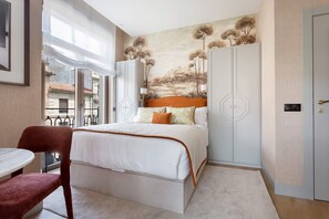 A bedroom with a bed, a chair, a table, and a wardrobe. - Elegant Salamanca Studio Isla de la Rua III (Salamanca)