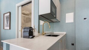 A modern kitchen with a white countertop, a gold faucet, and a built-in microwave. - Charming Studio in Salamanca Isla de la Rua II (Salamanca)