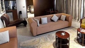 A modern living room with a sofa, coffee table, and a dining area. - Desert Inn Resort and Camp (Ras Al Khaimah)