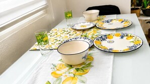 A dining table with a lemon-themed tablecloth, a bowl, and plates. - Centrally located two-bedroom apartment with patio. Charming (Córdoba España)