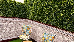 A patio with two chairs, a small table, and a decorative wall. - Centrally located two-bedroom apartment with patio. Charming (Córdoba España)