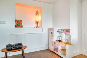 Une cuisine miniature pour enfants, avec un four à micro-ondes, un four et un évier.