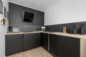 Eine moderne Küche mit Mikrowelle, Kaffeemaschine und Brotbackmaschine auf der Arbeitsfläche.