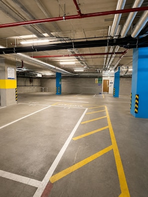 A multi-level parking garage with concrete floors, yellow parking lines, and blue pillars. - Free Underground Parking l 5 mins Wembley Stadium/Arena/Park Station (Wembley)