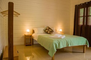 A room with a bed, two bedside tables, a hanging light fixture, and a window with curtains. - Welfare Agroturismo (Trindade)