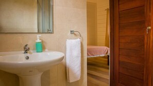 Une salle de bain équipée d’un lavabo, d’un miroir et d’un porte-serviettes.