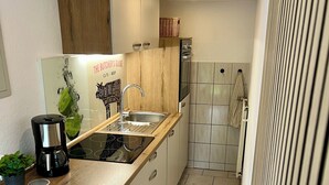 Een moderne keuken met een houten aanrecht, een roestvrijstalen spoelbak en een geïntegreerde vaatwasser.