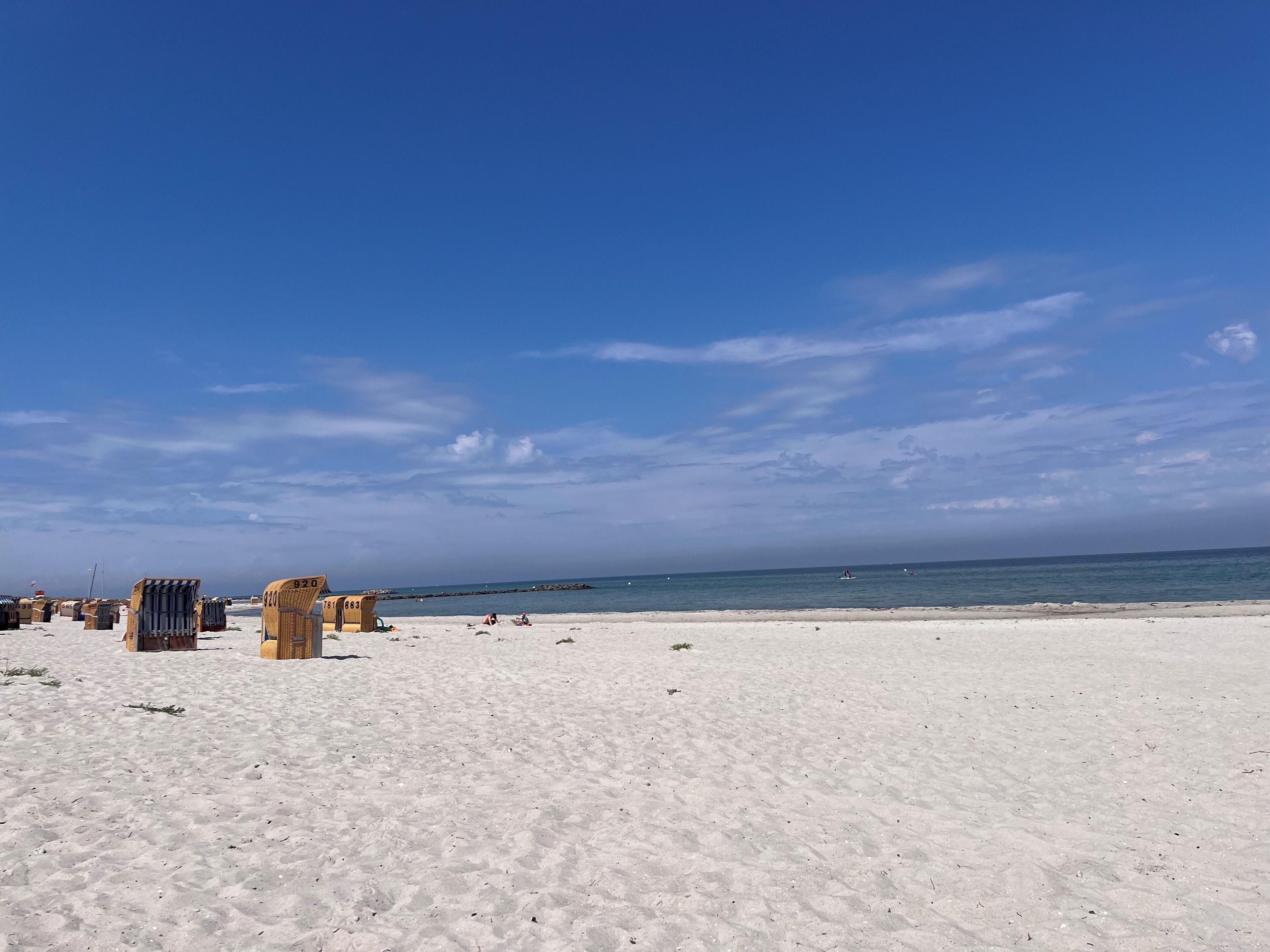 A beach with white sand and a clear blue sky.