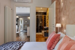 Ein Schlafzimmer mit Bett, Kissen, Nachttisch und Lampe.
